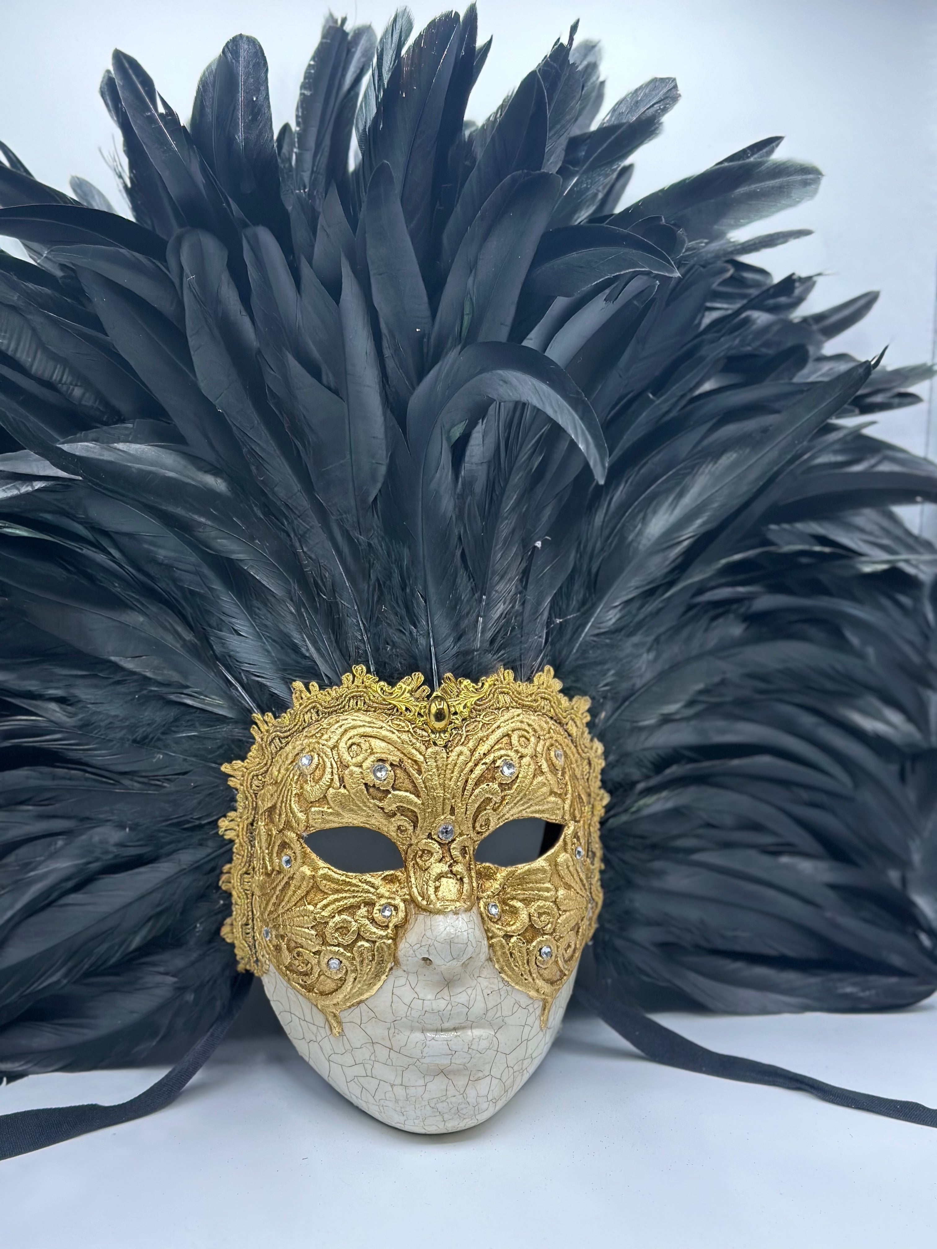 Full-face golden Venetian mask with black feathers